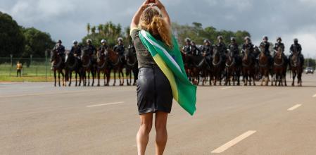A demonstrator gestures towards members of security forces as supporters of Brazil's former President Jair Bolsonaro leave a camp outside the Army Headquarters, in Brasilia, Brazil, January 9, 2023. REUTERS/Amanda Perobelli TPX IMAGES OF THE DAY
