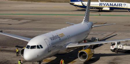 PASAJE DE UN AVION DE VUELING ESPERANDO PARA DESEMBARCAR MIENTRAS POR DETRAS PASA OTRO DE LA COMPAÑIA LOW COST DE RYANAIR