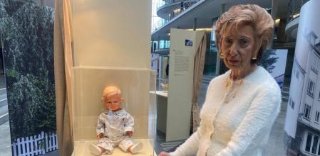 Lore Mayerfeld poses next to an 80-year-old blonde baby doll on display during the opening of the exhibition #{emoji}147;16 objects #{emoji}150; 70 years of Yad Vashem#{emoji}148; at the Paul-Loebe-Haus parliamentary building in Berlin, on January 24, 2023. - An 80-year-old blonde baby doll called Inge. A hand-carved Torah scroll case that survived a concentration camp. A beloved piano that joined a German Jewish family in exile. Israel's Yad Vashem Holocaust memorial has for the first time in its 70-year history lent prized possessions from its permanent collection to Germany for an exhibition opening on January 24, 2023 in Berlin. (Photo by Julien GATHELIER / AFP) / TO GO WITH AFP STORY by Deborah COLE