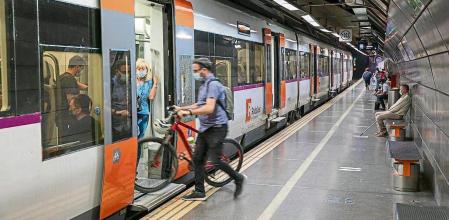 Un usuario de la red de Rodalies de Renfe, en Catalunya, accede al tren con una bicicleta&nbsp;
