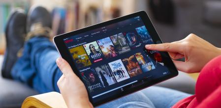 İstanbul, Turkey - July 1 2018: Woman using tablet computer and looking an online streaming platform. The tablet pc is an iPad Air 2, developed by Apple Inc.