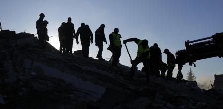 Un equipo de rescate sobre las ruinas de un edificio de Antakya