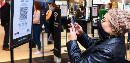 Una mujer escanea un código QR en una tienda