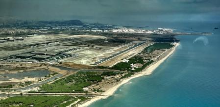 Vista aérea del entorno aeroportuario con la laguna del Remolar en primer término y la desembocadura del Llobregat y el puerto al fondo