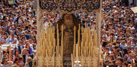 GRAFAND040. SEVILLA, 02/04/2023.- El paso de palio de la Virgen Nuestra Señora de la Hiniesta de la Hermandad del mismo nombre, fundada en el siglo XV, entre la multitud tras salir la Iglesia de San Julián de Sevilla para la salida procesional de la cofradía en un Domingo de Ramos con temperaturas más altas de lo normal en esta época del año en la capital andaluza.