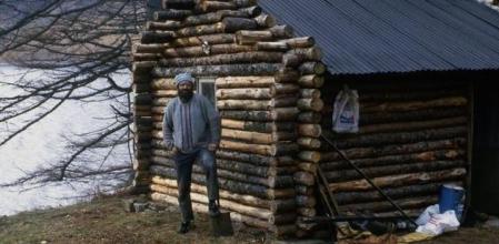 Ken Smith frente a su cabaña