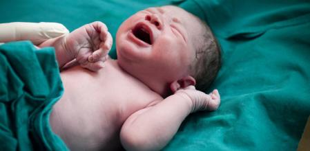 baby cries as a doctor prepares to go from mom