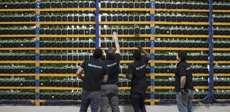 Trabajadores custodiando maquinaria de minería de criptoactivos, en Canadá