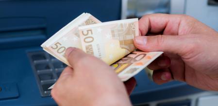 Un cliente de banca sacando dinero de un cajero automático