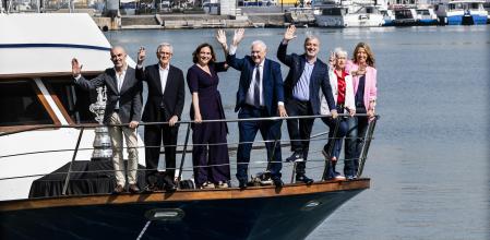 Los candidatos, saludando desde la embarcación, durante la sesión de ayer