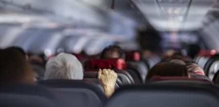 Fear of flying airplanes. Hand holding airplane seat.