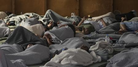 Algunos de los náufragos rescatados descansan en un edificio habilitado en el puerto de Kalamata
