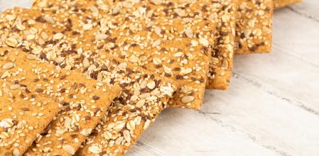 Pile of crackers on gray wooden background.