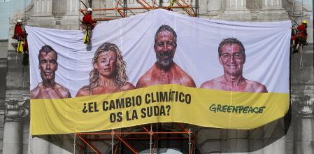 Activistas de Greenpeace despliegan una lona en la Puerta de Alcalá de Madrid durante la campaña de las pasadas elecciones