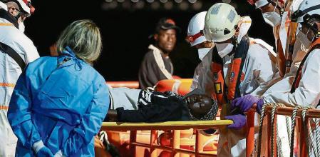 Rescuers carry a migrant out of a Spanish coast guard vessel, at the port of Arguineguin, in the island of Gran Canaria. Spain, July 25, 2023. REUTERS/Borja Suarez