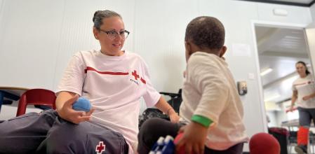 Una voluntaria atiende a uno de los pequeños llegados a Alicante.