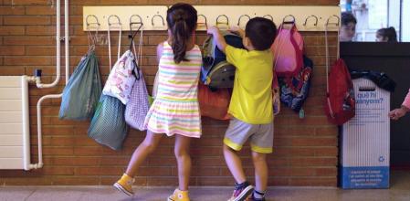 GRAFCAT1373. BARCELONA, 14/09/2020.- Dos niños hacen cuelgan sus mochilas en la Escola Catalonia de Barcelona este lunes, cuando un millón y medio de alumnos catalanes vuelven a las escuelas e institutos en un inicio de curso marcado por la COVID-19, que impedirá los abrazos de reencuentro y obligará a los estudiantes a acceder a las aulas de forma escalonada, con mascarilla, las manos lavadas y la temperatura tomada. EFE/Enric Fontcuberta