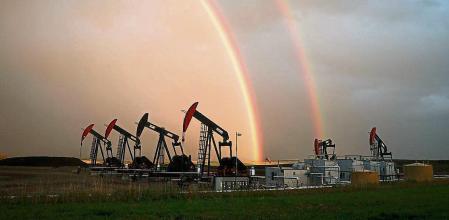 A rainbow appears to come down on pumpjacks drawing out oil and gas from wells near Calgary, Alberta, Monday, Sept. 18, 2023. Canada has the third largest oil reserves in the world and is the world's fourth largest oil producer. (Jeff McIntosh/The Canadian Press via AP)