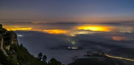 Los pueblos de la Plana de Vic se ven con las luces encendidas entre las nieblas.