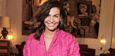 Inés Sastre, vestida con blusa y falda de tafetán de seda en un color fucsia vibrante de la colección crucero de Dior y pendientes Serpenti Viper de Bulgari