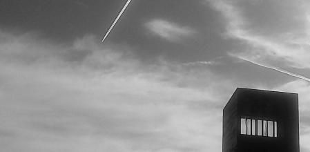 Una estela de condensación junto a la obra 'L’Estel ferit' de la Barceloneta.