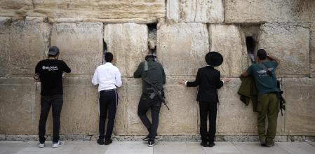 JERUSALEM - NOVEMBER 12: Religious Jews, some carrying weapons, pray at the Western Wall in the Old City on November 12, 2023 in Jerusalem. A month after Hamas's October 7 attacks, the country's military has continued its sustained bombardment of the Gaza Strip and launched a ground invasion to defeat the militant group that governs the Palestinian territory. (Photo by Christopher Furlong/Getty Images) *** BESTPIX ***