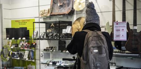 Una transeúnte mirando en el escaparate de una tienda de segunda mano