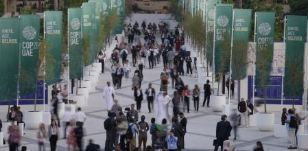 People walk through the COP28 U.N. Climate Summit, Monday, Dec. 4, 2023, in Dubai, United Arab Emirates. (AP Photo/Peter Dejong)