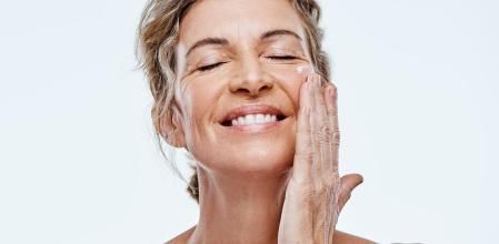 Una mujer aplicándose una crema antiarrugas.