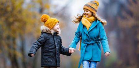 Dos niños paseando bien abrigados.