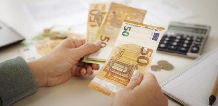 Una persona cuenta dinero, en una imagen de recurso