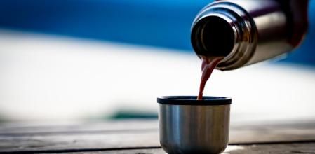 Un termo sirviendo una taza de café.