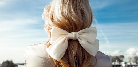 Una mujer con la melena recogida con un lazo.