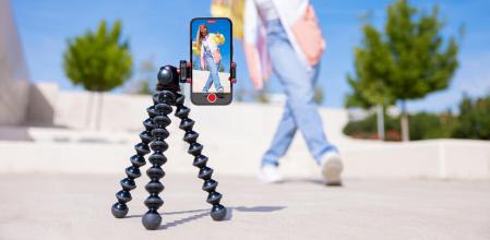 Una mujer grabando un vídeo con su móvil usando un trípode.