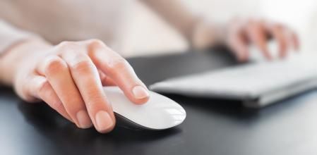 Una persona usando un ratón inalámbrico.
