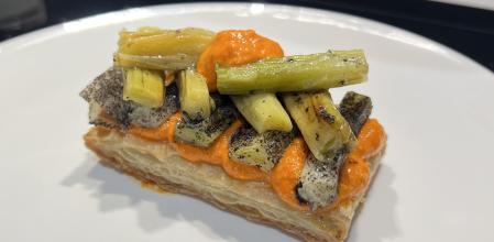 Hojaldre con romesco, calçots y polvo de sus brasas