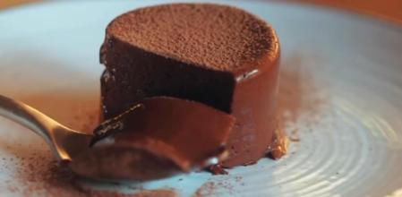 Flan de chocolate sobre un plato con una cuchara