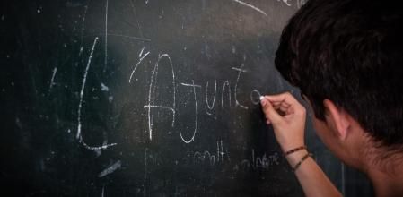 Alumno escribe en la pizarra de un centro de Barcelona