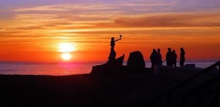 La puesta de sol enmarca la silueta de la estatua de La Libertad.