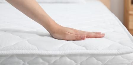 Una persona tocando lo suave que es un colchón.