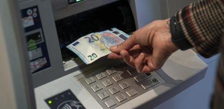 Una usuaria de banca sacando dinero de un cajero