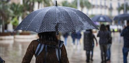 Mujer caminando bajo la lluvia.