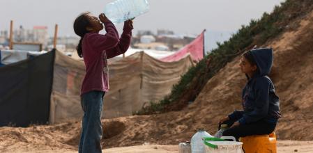 TOPSHOT - Displaced Palestinian children wait for a water supply tank to fill their containers amid soaring temperatures at a tent camp in Rafah in the southern Gaza Strip on April 26, 2024 amid the ongoing conflict between Israel and the Palestinian militant group Hamas. (Photo by MOHAMMED ABED / AFP)
