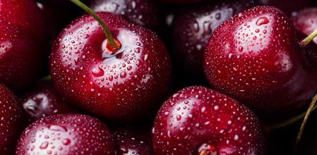 Fresh ripe black cherries on a blue stone background Top view Close up.
