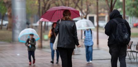 Varias personas con paraguas pasean por una de las calles de la ciudad, a 12 de mayo de 2023, en Barcelona, Catalunya (España). Casi todas las comarcas de Catalunya estarán pendientes hoy de una nueva tanda de chubascos y tormentas como consecuencia de la irrupción de una masa de aire frío que ha disparado la inestabilidad atmosférica. El Servei Meteorològic de Catalunya (Meteocat) ha emitido un aviso por peligrosidad de lluvias intensas de nivel moderado (1/6), desde el jueves 11 de mayo hasta hoy por la tarde, con posibilidad de lluvias intensas superando los 20mm en 30 minutos y acompañadas localmente por granizo.