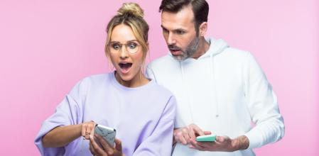 Una pareja se asombra con lo que están mirando en el móvil