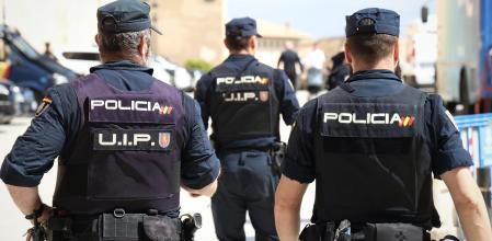 Agentes de la Policía Nacional de espaldas.