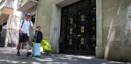 Un turista pasa por delante de una finca donde se ofrecen pisos turísticos, en Barcelona