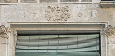 Escudo esculpido en cuyo centro se puede observar una herradura sobre un yunque, que indicaría una de las actividades que ha acogido el inmueble en su historia ha sido una herrería