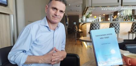 Abdelkhalak Namji, junto a un ejemplar de su obra durante la entrevista.